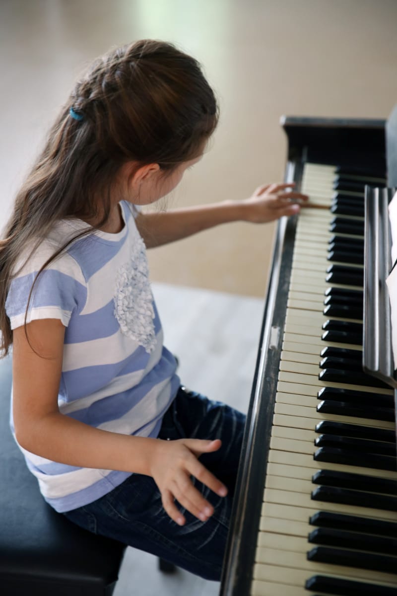 A young girl practising at the piano
